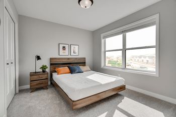 a bedroom with a large window and a bed with a wooden headboard
